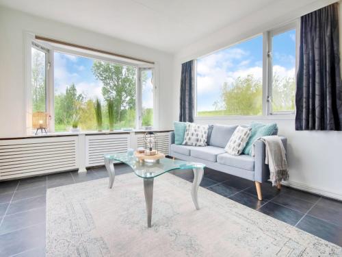 a living room with a couch and a glass table at Water Villa in Ooltgensplaat near Volkerak in Ooltgensplaat