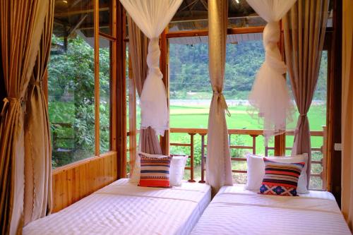 Mù Cang ChảiにあるChải Eco Homeの大きな窓のある部屋にベッドが2つある