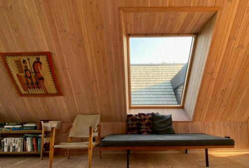 a room with a window and a bench and a chair at Architect-Designed A-House By Saksild Beach in Odder