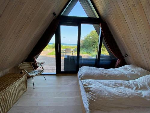 a room with a bed and a couch and a window at Architect-Designed A-House By Saksild Beach in Odder