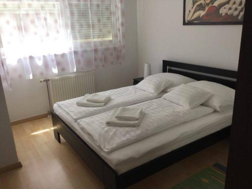 ブダペストにあるAdam's Apartment and Free Parkingのベッドルームにタオル2枚が付いたベッド1台