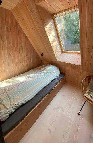 a bed in a small room with a window at Architect-Designed A-House By Saksild Beach in Odder