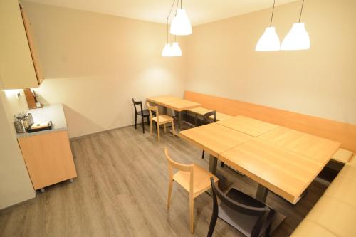 a dining room with wooden tables and chairs at Rooms Kozmus in Brestanica