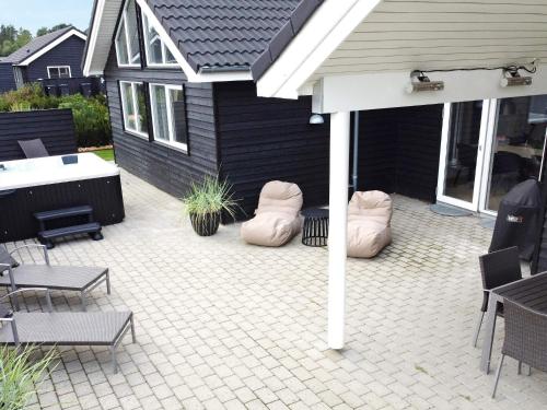 a patio with chairs and bean bags in front of a house at Luxury Retreat with Pool - By Traum Ferienwohnungen in Nørre Nebel