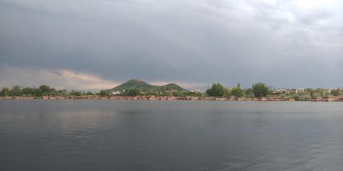 a large body of water with houses in the background at Houseboats Jackson Heights in Srinagar