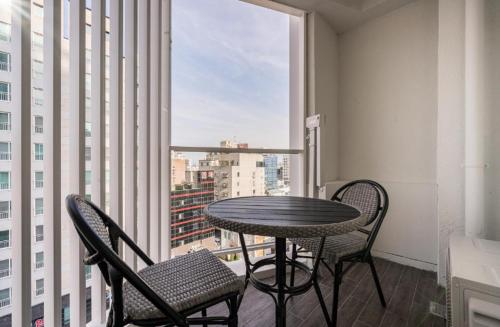 a table and chairs in a room with a window at Pohang Hotel La Terrace in Pohang