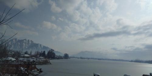 a large body of water with a mountain in the background at Houseboats Jackson Heights in Srinagar