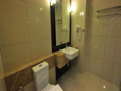 a bathroom with a toilet and a sink at Tanzeno Hotel in Nong Khai