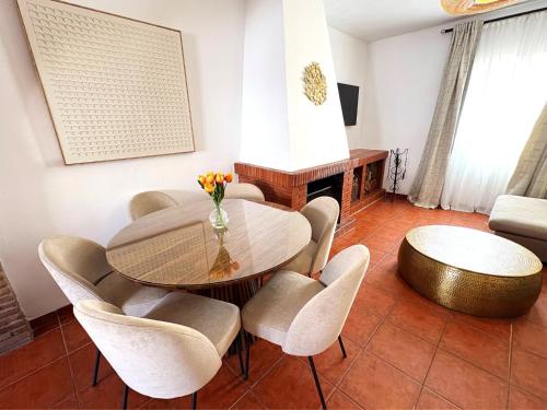 a living room with a table and chairs and a couch at XXVIII- La Casa De Las Flores in El Colmenar