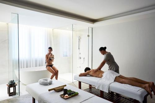 a woman standing on two beds and a man in a bath room at The Lind Boracay in Boracay