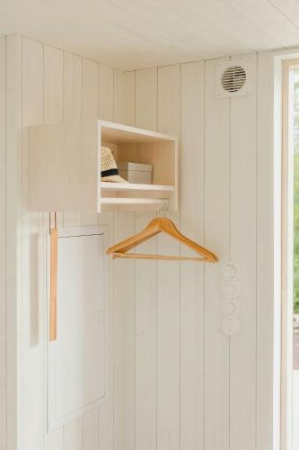 a white room with a shelf and a door at Modern Summer House Near The Sea In Ljugarn in Ljugarn