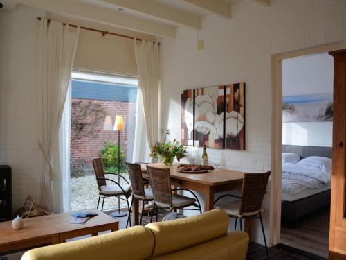 a living room with a table and chairs and a bed at Bungalow in Noordwijkerhout near Lake in Noordwijkerhout