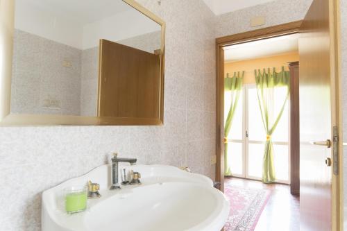 y baño con lavabo blanco y espejo. en Vacationers Refuge en Anzio