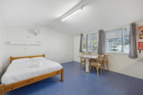 Un dormitorio con una cama y una mesa con sillas. en Valla Beach Holiday Park, en Valla Beach