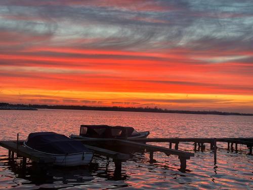 a boat is docked at a dock with a sunset at woonboot de dobber loosdrechtse plassen 6-8 personen in Loosdrecht
