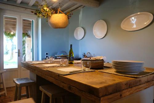 una cocina con una mesa de madera con platos y vasos. en Restored Farmhouse Between Rome And Florence, en Parrano