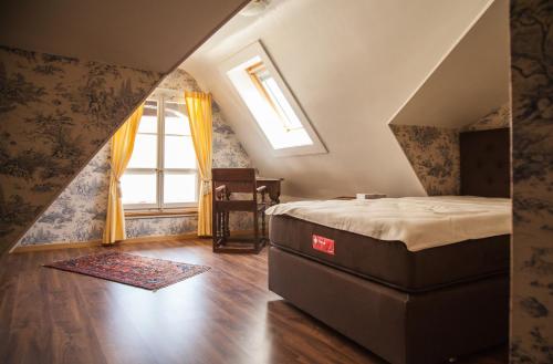 una camera con letto e finestra di Hôtel Les Vieux Toits a Neuchâtel