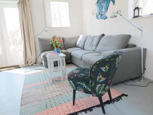 a living room with a couch and a chair at Holiday Home in Dishoek near Southern Beach in Dishoek