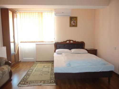 a bedroom with a bed and a window and a rug at Anga Yerevan Apartments in Yerevan
