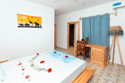 a bedroom with a bed and a table and a desk at Tikipalmbeachhotel in Paje