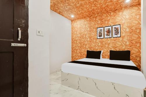 Un dormitorio con una cama con dos cuadros en la pared. en Hotel O The Signature Stay, en Nueva Delhi