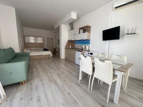 a living room with a couch and a table and chairs at SEA Apartment Maria Balchik in Balchik