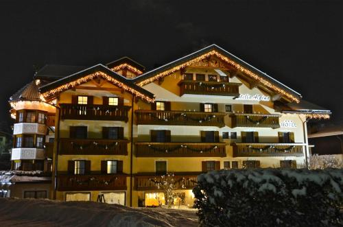 a large building in the snow at night at Hotel Stella Alpina in Moena