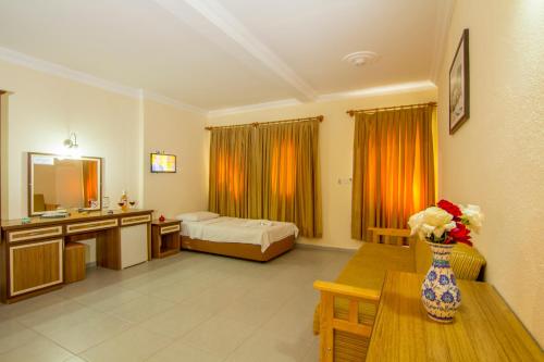 a hotel room with a bed and a vase of flowers on a table at Hotel Karbel Sun in Oludeniz