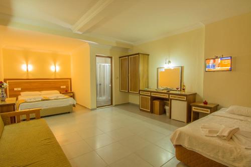 a hotel room with two beds and a sink at Hotel Karbel Sun in Oludeniz