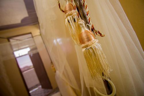 a white curtain hanging on a window in a room at Grande Hotel in Isiolo