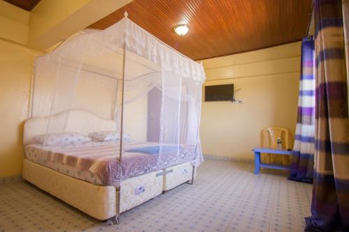 a bed with a canopy in a room at Grande Hotel in Isiolo