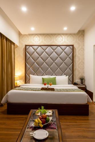 a bedroom with a large bed with a tray of fruit at Aliste Millennium Huda City Centre in Gurgaon