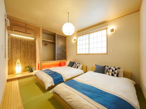 two beds in a room with a window at Yadoya Asakusa Asagao in Tokyo