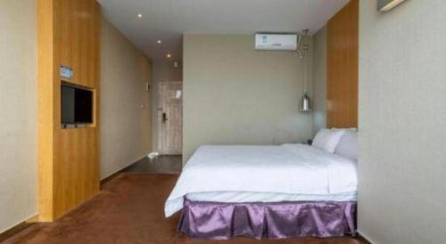 a bedroom with a large white bed and a television at The Art Hotel in Shenzhen