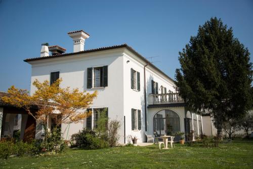 a large white house with a tree in the yard at Villa Franca in Franciacorta in Passirano