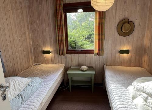 two twin beds in a room with a window at Holiday Home By Limfjord With Historic Charm in Farsø