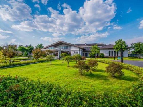 a large house with a green lawn in front of it at Linyi Blue Horizon International Hotel Yi He in Linyi