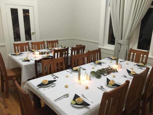 a dining room with a long table with white table cloth at Eddy's of Canowindra in Canowindra