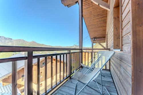 a wooden balcony with a chair on a deck at Appartement 8 personnes dans chalet privé au pied des pistes in Val Thorens