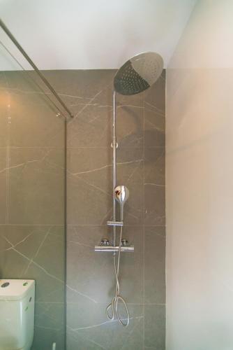 a shower with a shower head in a bathroom at WELCS VILLA 282 EMP con piscina compartida in Roses