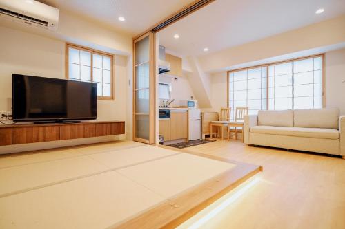 a living room with a flat screen tv and a couch at 秋叶原嘉陽ビル in Tokyo