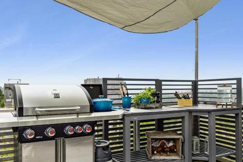 an outdoor kitchen with a grill on a balcony at Cabin With 360-Degree Views In Risør in Søndeled