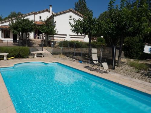ein blauer Pool vor einem Haus in der Unterkunft Cottage with River Views, Uzer in Uzer