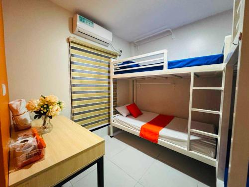 a small room with a bunk bed and a desk at OYO 1158 Kegama Residences 2 in Cavite