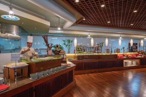 a restaurant with a chef preparing food in a kitchen at Sokha Angkor Resort in Siem Reap