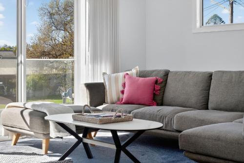 a living room with a couch and a coffee table at Forsyth Retreat - Modern Townhouse in Wagga Wagga