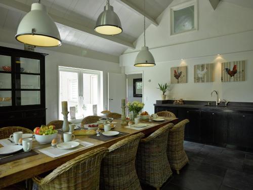a dining room with a long wooden table and chairs at Farmhouse in Zuidzande near Cadzand Beach in Zuidzande