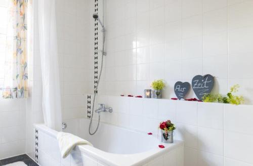 a white bathroom with a tub and a sink at ausZEIT - Ihr Sibyllenbad Gästehaus in Neualbenreuth