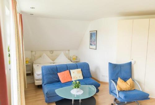 a living room with a blue couch and a bed at ausZEIT - Ihr Sibyllenbad Gästehaus in Neualbenreuth