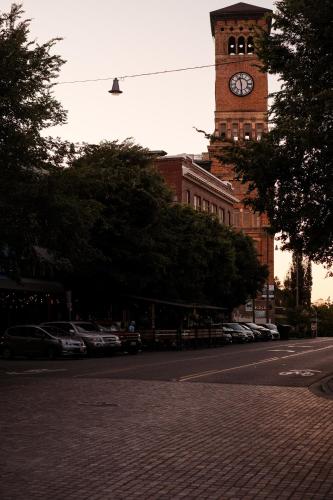 a clock tower on a building with cars parked at Bos Cozy Victorian Top Floor Duplex Unit with Puget Sound views in Tacoma